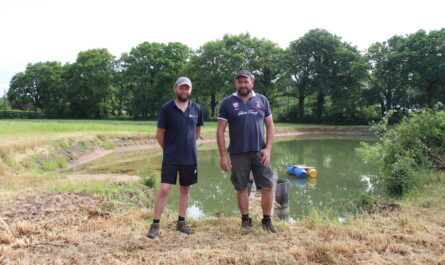 Ludovic Lambert (à gauche) et son frère David devant l’étant de 3000 m3 qu’ils ont fait creuser pour stocker l’eau de pluie récupérée sur les toitures de leurs bâtiments d’élevage.